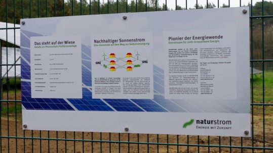 Ein Schild am Zaun der Photovoltaikanlage informiert über die technischen Details der Anlage.